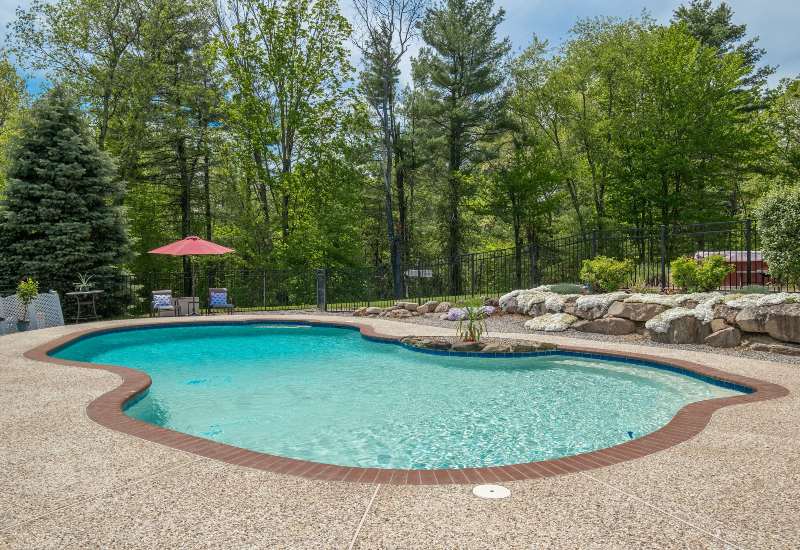 Backyard gunite swimming pool with clear water and landscaped surroundings in Virginia & Maryland