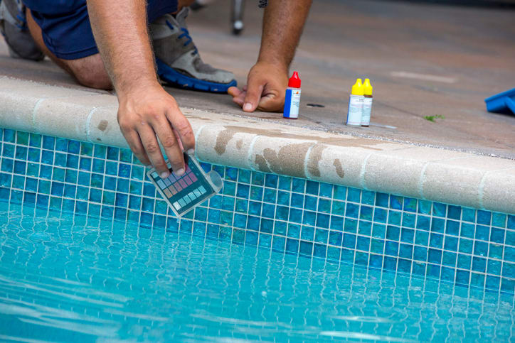 Pool testing kit being used in a swimming pool