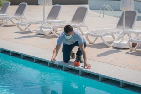 Man Testing and Balancing Pool Chemicals for Maintenance in Maryland