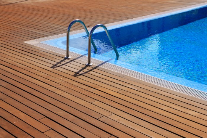 Blue swimming pool with teak wood flooring deck in VA, DC and MD
