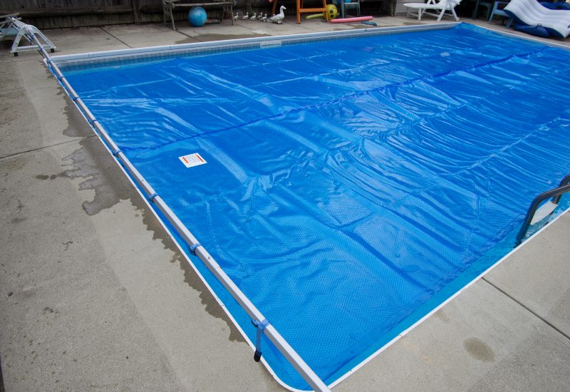 A Swimming Pool Covered with a Blue Winter Pool Cover in Virginia & Maryland