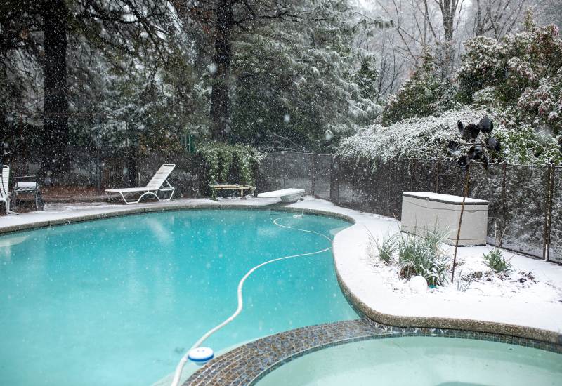 Snowy Backyard Pool with Lounge Chairs and Trees in Winter in Virginia & Maryland