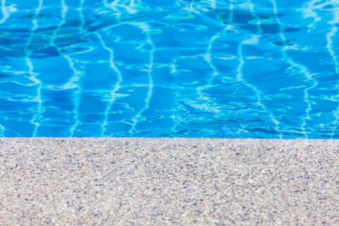 Close-up of a textured pool edge with clear blue water in Virginia and Maryland