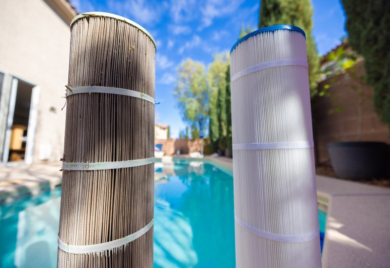 Dirty and clean pool filter cartridges beside swimming pool in Virginia & Maryland